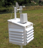 Vue 3/4 arrière de notre abri météo artisanal.<br>Le pluviomètre est relié au toit par 2 vis et 2 tiges filetées.<br>Des entretoises permettent de compenser la pente du toit afin de maintenir l'instrument à l'horizontale.