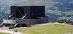 Gare supérieure de l'Ahornbahn.<br>Les points d'ancrage des câbles porteurs sont impressionnants.<br>A l'arrière plan, le domaine skiable du Penken.