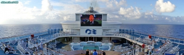 <i>Grand Princess</i>, <i>Movies under the stars</i>.<br>Les Amerloques sont des fous de télévision. Pour éviter qu'ils ne restent enfermés dans leur cabine, un écran géant (27 m<sup>2</sup>) à LED est disposé à l'extérieur.<br>Ah, la cérémonie d'investiture d'Obama, au bord de la piscine, avec un cocktail spécial <i>Stars and Stripes</i> (si, si, ils l'ont fait !), c'est vraiment les vacances ! Pas de bol, on était à la plage !