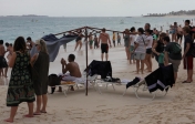 [no_rights] Plage d'Atlantis, Paradise Island, Bahamas.<br>Les gens commencent à s'inquiéter de la couleur du ciel.<br>Le parasol en lambeaux semble annoncer l'apocalypse.