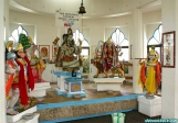 Île de Trinidad, Temple by the Sea.<br>De gauche à droite,<br>Hanuman, le dieu-singe,<br>En partie masqué, avec une tête d'éléphant, Ganesh, dieu de la sagesse,<br>au centre, Vishnou, dieu de la conservation et de la protection,<br>Durga, la déesse mère, assise sur un lion,<br>et enfin Krishna.<br>Au pied de chaque divinité, une corbeille sert à recueillir les offrandes.
