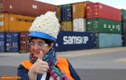 Cargo porte conteneur <i>Samskip Express</i>, port de Dublin.<br>Un port étant une zone dangereuse, le casque et le gilet fluorescents sont obligatoires.<br>Nous ne savons pas si le règlement autorise le port d'un bonnet sur le casque...