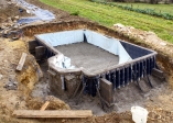 23/11/2007.<br>Le béton a été coulé. Il va reposer ainsi pendant 3 semaines.<br>On remarque des tiges d'acier qui sortent du coffrage: elles serviront de support à la terrasse.<br>Des contreforts en parpaing on été disposés tout au long du coffrage. Admirez l'espèce de merdier infâme (je ne trouve pas d'autres mots) qui se trouve sous l'escalier: le centre Beaubourg nous en a offert une fortune, mais on a refusé !