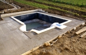 10/01/2008.<br>Le muret est habillé de fausses pierres <i>Bradstone</i>: c'est déjà plus joli, non ?<br>La margelle de la piscine est posée, sauf sur l'escalier.<br>La terrasse a été étendue jusqu'à la baie vitrée du salon.