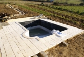 10/02/2008.<br>La terrasse est complète, y compris le plancher en bois, mais les joints ne sont pas encore complets.<br>Le soleil a fait son apparition, ce qui a fait éclore un Transat !<br>Le fond de la piscine a été recouvert d'une chape lisse. Les joints de la margelle sont faits.