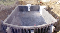 Assemblage panoramique de 3 clichés.<br>La structure est bétonnée, la chape du fond est en place.<br>Sur la paroi opposée, le groupe de filtration.