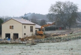 Remblaiement. La portée de la pelle est vraiment impressionnante.<br>A noter, la cheminée de la maison fume: on est en jour rouge, donc chauffage exclusivement au bois !