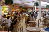 Intérieur d'un <i>Mall</i> de Los Angeles, zone du <i>Food Court</i>. Ici sont rassemblés les principales enseignes de restauration rapide. En plus des classiques hamburgers et pizzas, on y trouve des restaurants chinois, japonais et mexicains. C'est globalement assez savoureux et peu onéreux, mais gare à la ligne, car c'est vraiment très riche !