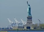 New York.<br>La statue de la liberté, vue depuis <i>Battery Park</i>.<br><font size=-1>Le cliché est pris à près de 3 kilomètres, avec une focale de 400 mm (éq. 24x36).<br>Au fond, à 12 kilomètres, derrière les grues: Bayonne Bridge, pont reliant Staten Island (district de New York), et Bayonne (New Jersey).</font>