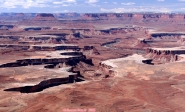 CANYONLANDS, depuis la pointe d'<i>Island in the Sky</i>.<br>Le panorama laisse sans voix.<br>Sur cette image, on distingue une piste pour véhicules tout-terrain, en bas à gauche: cela donne une idée des dimensions.<br>Parcourir cette route en 4x4 requiert 2 à 3 jours: camping obligatoire !<br>A droite, les méandres de la Green River, affluent du Colorado.