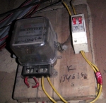 Le bon vieux compteur électromécanique et son disjoncteur.<br>Admirez le ruban adhésif rouge en bas à droite, sans doute pour protéger un raccord bricolé...
