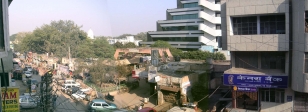 New Delhi, montage panoramique.<br>Un building moderne cotoie des bâtiments vétustes.<br>Le panneau de compteurs électriques, au milieu et en bas de la photo, est détaillé dans la rubrique <i>Electricité</i>.<br>La boutique à l'enseigne bleue, en bas à droite, est une banque. Vous voulez ouvrir un compte ?